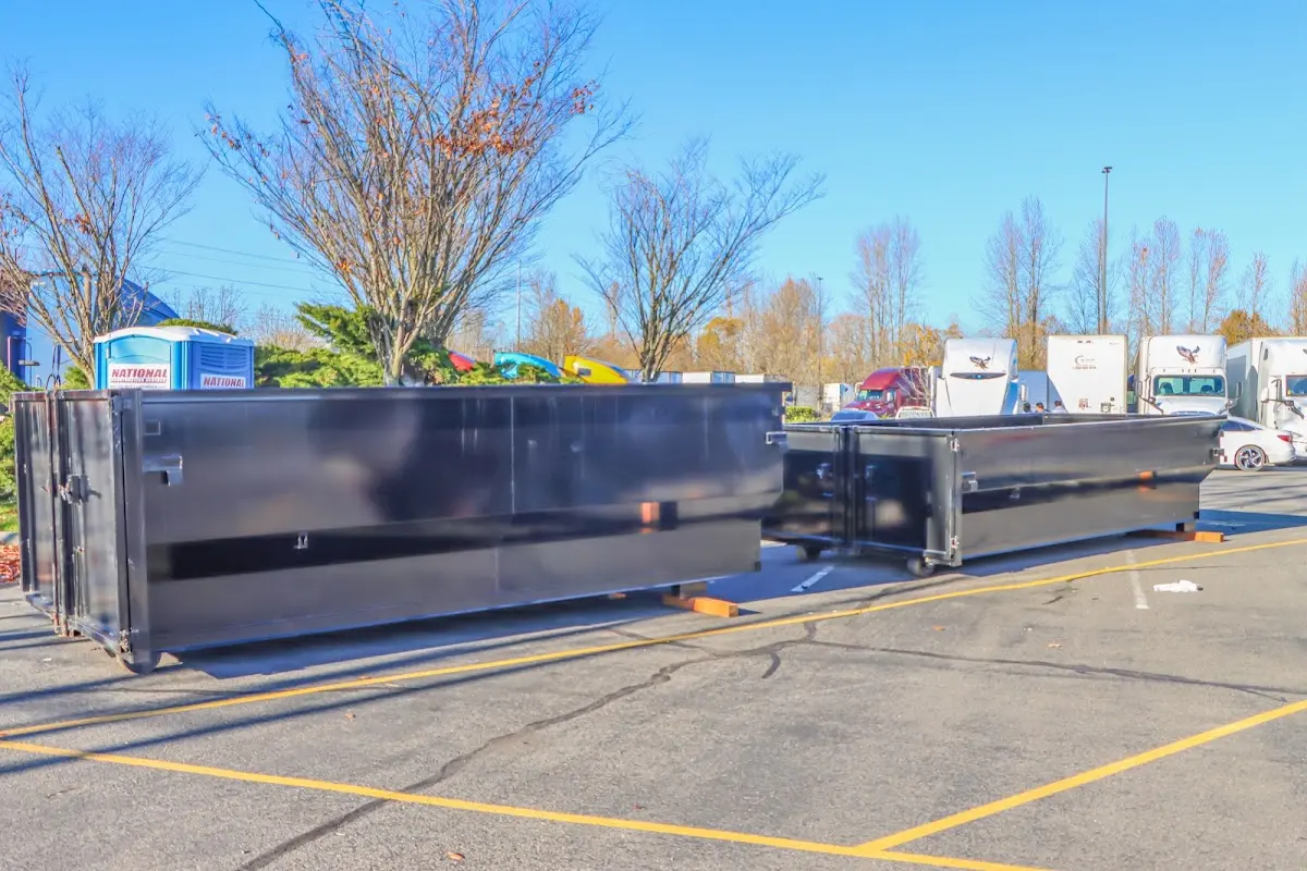 Professional dumpster rental service with roll-off container on residential driveway in East Peoria